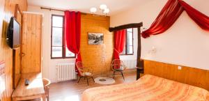 a bedroom with a bed and red drapes at Au Sans Souci in Saint-Paul-lès-Monestier