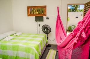 een slaapkamer met een bed met roze hangmatten erin bij B&B Chalé Jardins in Lagoinha