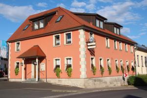 SulzfeldにあるLandgasthof zum Hirschenの赤い屋根の大きなオレンジ色の建物