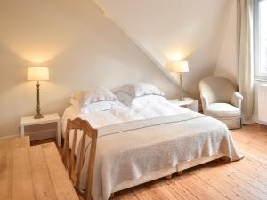 ein Schlafzimmer mit einem Bett, zwei Lampen und einem Stuhl in der Unterkunft B&B Salve in Brüssel