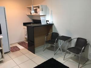 a room with two chairs and a table and a desk at Flats no Quartier e Village Apart Hotel in Três Poços