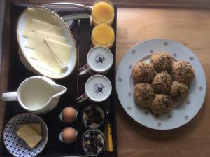 Bed and Breakfast - Stakdelen 47 في Allerup: صينية طعام مع المافن والجبن والبيض