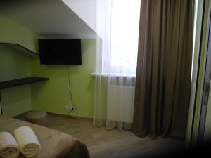 1 dormitorio con 1 cama y ventana con toallas en Cherdachok en Tiflis