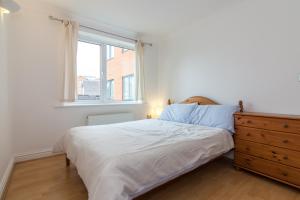 um quarto com uma cama, uma cómoda e uma janela em Rest & Recharge - Birley View em Manchester