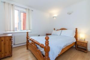 a bedroom with a wooden bed and a window at Rest & Recharge - Birley View in Manchester