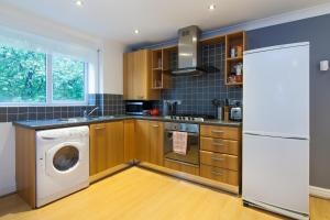 a kitchen with a washer and dryer in it at Rest & Recharge - Birley View in Manchester