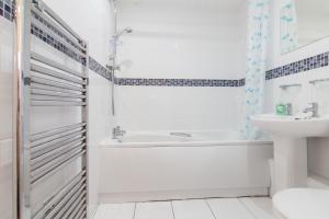 biała łazienka z wanną i umywalką w obiekcie Rest & Recharge - Birley View w Manchesterze