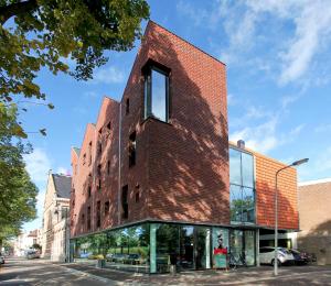 a brick building with a clock on the side of it at Design Hotel Modez in Arnhem