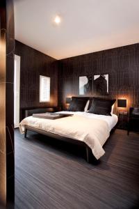 ein Schlafzimmer mit einem großen Bett und einer schwarzen Wand in der Unterkunft Design Hotel Modez in Arnhem