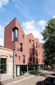 a red brick building with a window on a street at Design Hotel Modez in Arnhem