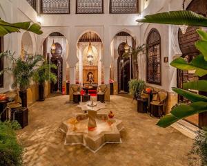 a lobby with tables and chairs in a building at Riad Omri in Marrakech