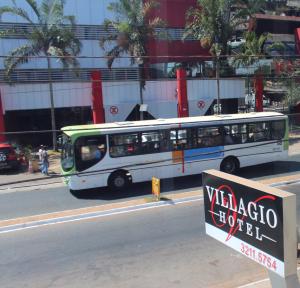 a bus is parked on the side of a street at Luz Hotel in Goiânia