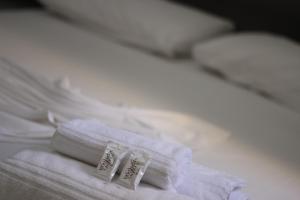 a pair of white towels sitting on top of a bed at Luz Hotel in Goiânia