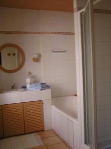 La salle de bains est pourvue d'une baignoire, d'un lavabo et d'un miroir. dans l'établissement Mas Alpilles Soleil, à Saint-Rémy-de-Provence