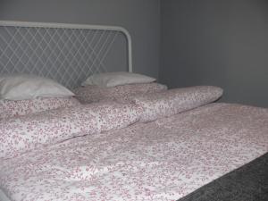 Una cama sin hacer con dos almohadas encima. en Pokój Uniejów, en Uniejów