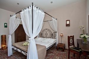 a bedroom with a canopy bed with white curtains at Hotel Tacl in Holešov