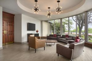 sala de estar con sofá, sillas y mesa en Ramada by Wyndham Beaver Falls, en Beaver Falls