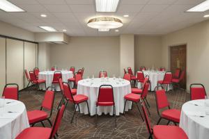 a conference room with white tables and red chairs at Ramada by Wyndham Beaver Falls in Beaver Falls +32 photos