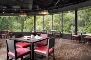 a restaurant with tables and chairs and large windows at Ramada by Wyndham Beaver Falls in Beaver Falls