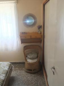 einen Korbstuhl in einem Zimmer mit einem Spiegel und einem Fenster in der Unterkunft Comodo Chalet en Gesell in Villa Gesell + 18 Fotos