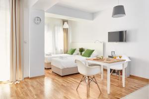 a white living room with a bed and a table at Moodeight Apartments in Skopje