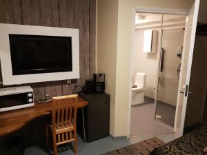 a room with a desk and a television on a wall at Gasthaus Patruuna in Joutseno +57 photos