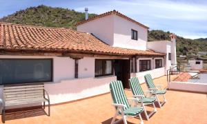 a group of chairs sitting on a patio with a tv at Casa Del Caminero En Tejeda in Tejeda