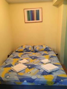 um quarto com uma cama com um edredão colorido em Apartment Vila Jezero em Zlatibor