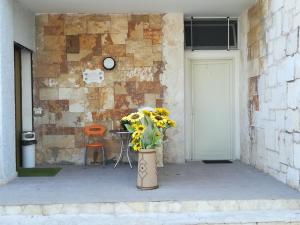 a vase filled with yellow flowers next to a door at I Girasoli in Bari