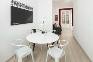 Apartamento Mediterraneo في مالقة: غرفة طعام بيضاء مع طاولة بيضاء وكراسي