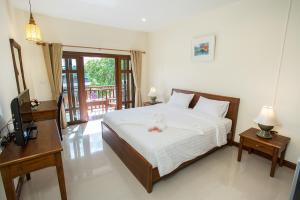 Un dormitorio con una cama y un televisor. en Oh Amphawa Boutique Resort, en Amphawa 12 fotos más