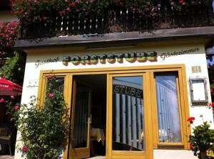 un restaurante con un cartel en la puerta en Gasthof Forststube, en Velden am Wörthersee