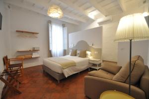 a hotel room with a bed and a couch at Port Antic Ciutadella by My Rooms Hotels TI in Ciutadella