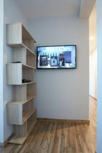 Una sala de estar con un televisor de pantalla plana en una pared. en Casa de Polentinos, en Ávila