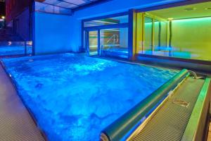 una piscina in una stanza con luci blu di Aspen Alpine Lifestyle Hotel a Grindelwald