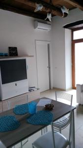 ein Esszimmer mit einem Tisch mit Stühlen und einem TV in der Unterkunft casa Marino in Capaccio-Paestum