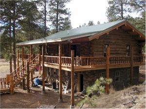 a log cabin with a porch and a deck at Lefty's Hideout in Custer +1 photo