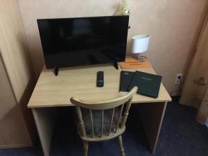 una scrivania con monitor e una sedia con televisore di Landhotel Kussmann a Wrexen