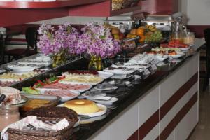 bufet z różnymi rodzajami żywności w obiekcie Hotel Turella w mieście União da Vitória
