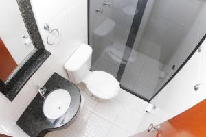 La salle de bains est pourvue de toilettes, d'un lavabo et d'une douche. dans l'établissement Hotel Turella, à União da Vitória