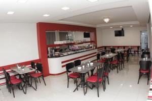 a restaurant with tables and chairs and a bar at Hotel Turella in União da Vitória