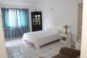 a bedroom with a white bed with yellow candles on it at Le Dattier -dreambeach in Flic-en-Flac