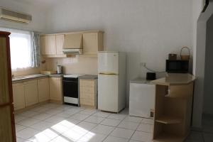 a kitchen with white appliances and a white tile floor at Le Dattier -dreambeach in Flic-en-Flac