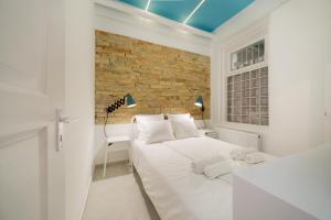 ブダペストにあるDesigner Dream Home In The Absolute Centerのレンガの壁の白い部屋(ベッド2台付)