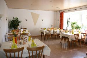 a dining room with white tables and chairs and a window at Landhotel Kussmann in Wrexen