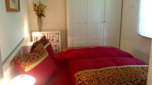 a bedroom with a red bed and a chair at Ferienhaus Mahlow BRA 011 in Mahlow