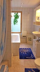 a bathroom with a tub and a sink and a blue rug at Ferienhaus Mahlow BRA 011 in Mahlow