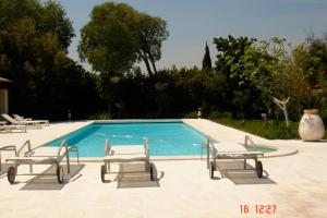 a swimming pool with lounge chairs next to it at Mas Alpilles Soleil in Saint-Rémy-de-Provence