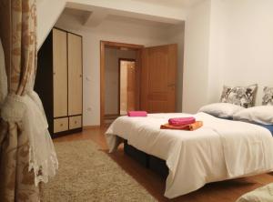 a bedroom with two beds with white sheets and pink towels at MiA Apartmani Visoko in Visoko