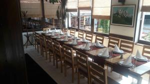 długi stół z krzesłami, kubkami i talerzami na nim w obiekcie Guest house Zavicaj Pale w mieście Pale